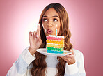 Woman, birthday and thinking with cake in studio for wish, excited face or happiness by gradient background. Happy model, girl and rainbow dessert for celebration, event and cream on finger at party