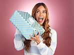 Woman, gift box and studio with thinking, happiness and surprise celebration by gradient background. Student girl, young and happy with present package, excited face and celebrate birthday with smile