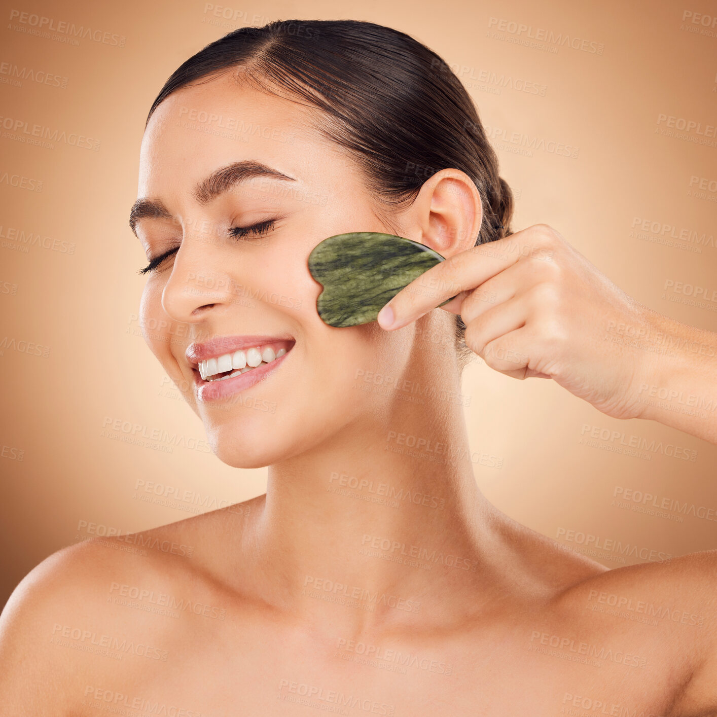 Buy stock photo Skincare, gua sha stone and woman face cleaning of a young person with happiness in a studio. Happy smile and dermatology treatment of a female with cosmetics, spa and cosmetology luxury facial