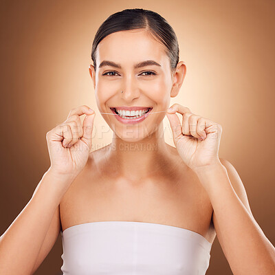 Buy stock photo Dental, floss and happy woman cleaning teeth for oral hygiene routine, self care flossing or tooth healthcare. Mouth plaque treatment, face portrait smile and studio female beauty on brown background