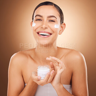 Buy stock photo Portrait, skincare and cream with a model woman in studio on a brown background for beauty or hydration. Face, beauty and product with a happy young female holding a container to apply moisturizer