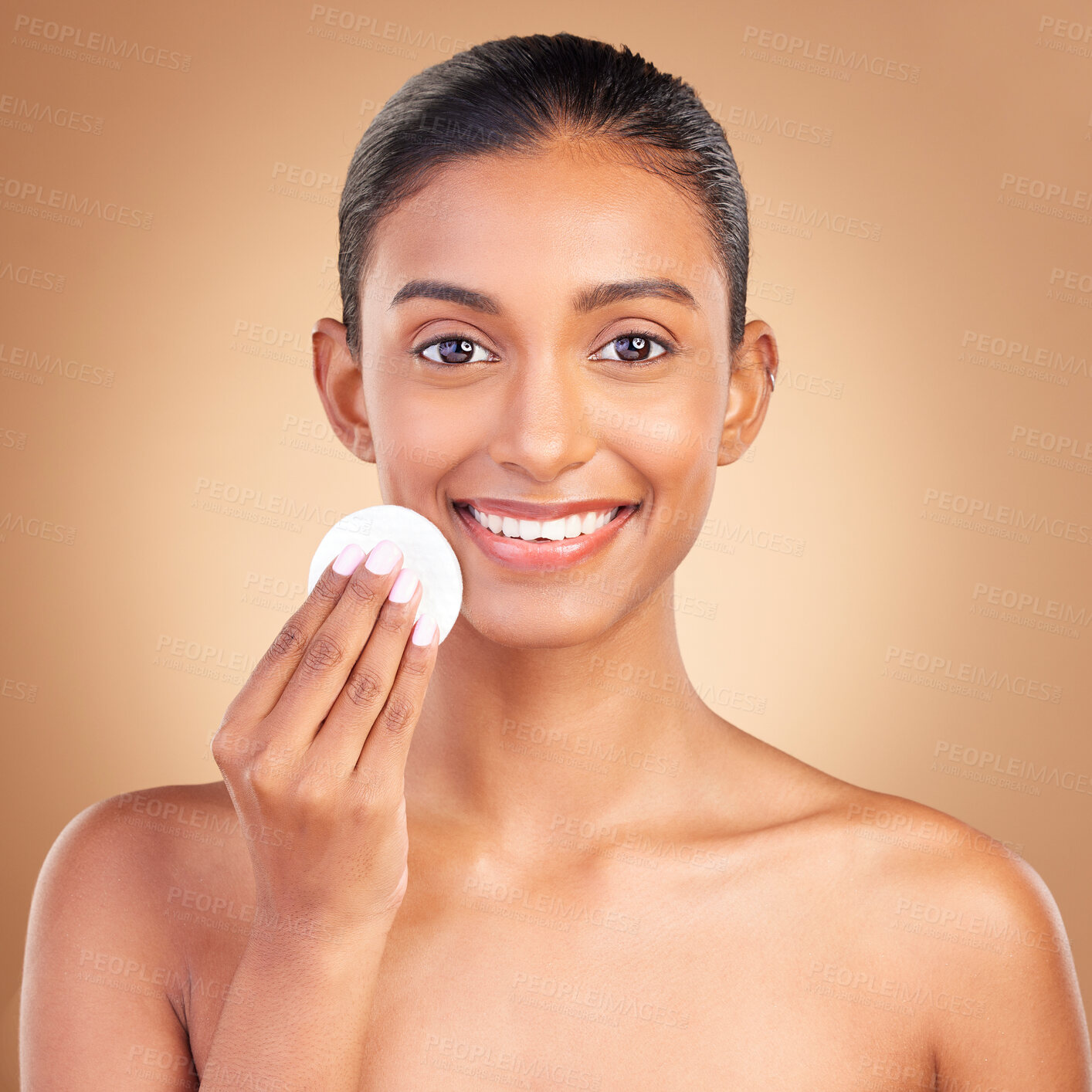 Buy stock photo Smile, skincare and cotton with portrait of indian woman in studio for self care, makeup remover and cosmetics. Beauty, clean and glow with model on brown background for results, natural and facial