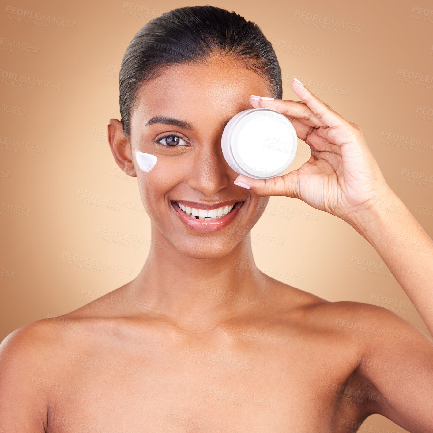 Buy stock photo Indian woman, skin and cream jar in portrait with smile, happiness and wellness by brown background. Happy model, lotion product and skincare in studio for dermatology, healthy and cosmetic beauty