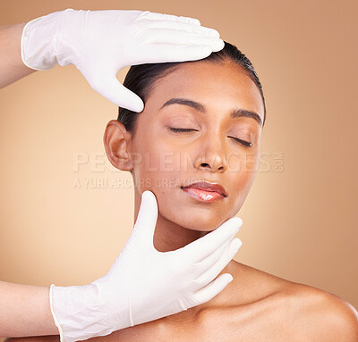 Beauty, skincare and hands with face of Indian woman in studio for cosmetics and plastic surgery. Spa treatment, dermatology and beautician with female on brown background for consulting