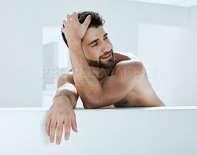 Buy stock photo Artistic, shirtless and handsome man is relaxed in a modern bathroom for hygiene and cosmetic skincare or self care. Model, male and person relax and calm in a white room for skin treatment