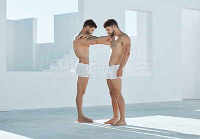 Buy stock photo Connection, gay and men touching arms for LGBTQ, power and creative contemporary art. Love, artistic and homosexual male couple or friends standing in underwear by a white open outdoor space.