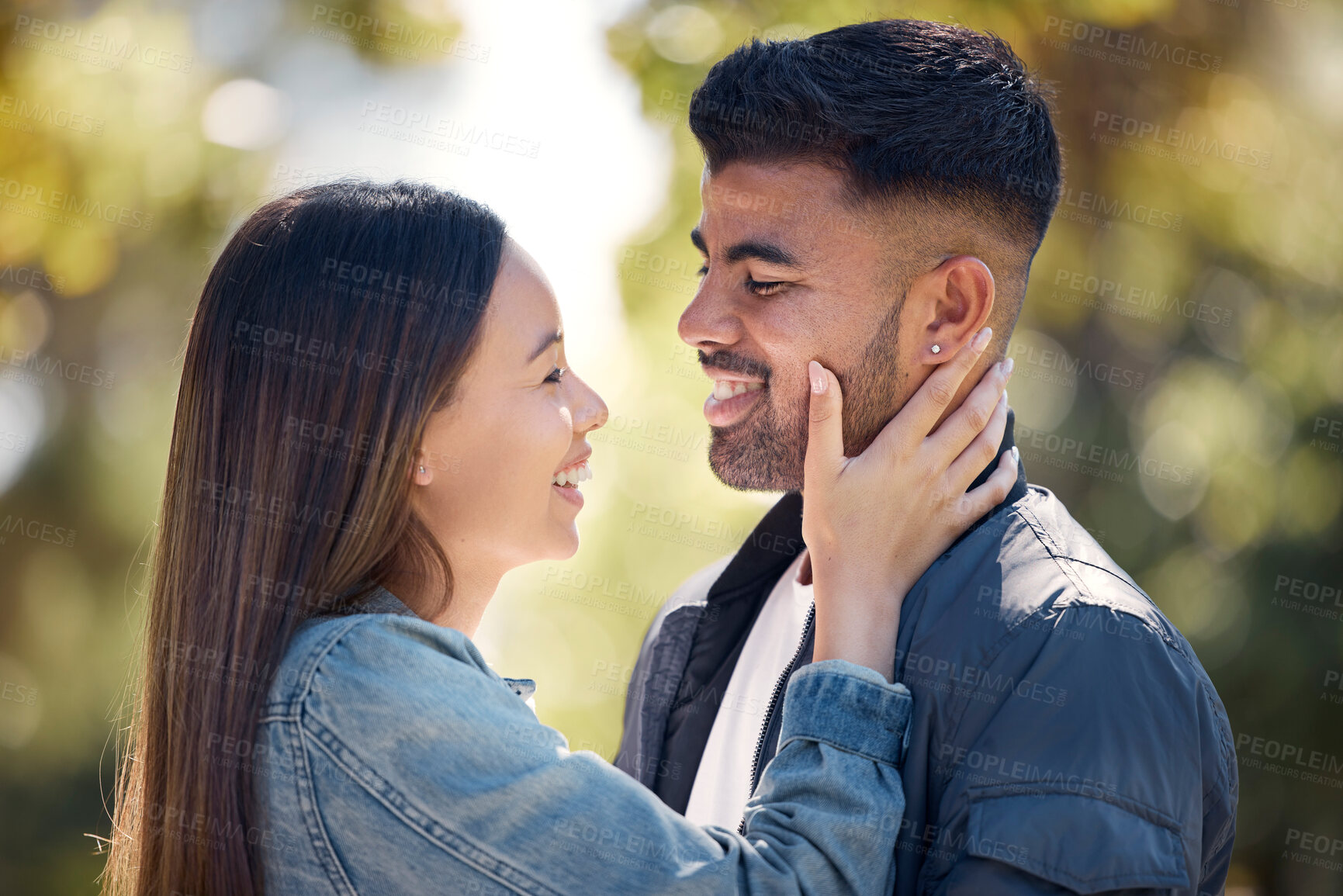 Buy stock photo Couple, outdoor and smile for love, care and happiness together in summer. Young woman with hand on face of a man at nature park for affection or trust on happy and romantic date or vacation to relax