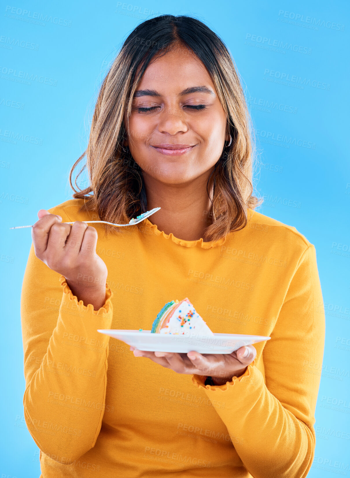 Buy stock photo Woman, fork and cake in studio for dessert, satisfied or eyes closed for happiness by blue background. Indian model, girl and happy for eating sweets, snack and test flavor for food, meal and diet