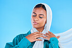 Calm woman, muslim and beauty of hijab in studio, blue background or color backdrop. Young female model, islamic culture or scarf with eyes closed, peace or religion of arabic fashion for eid mubarak