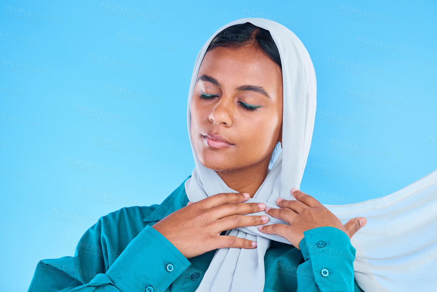 Buy stock photo Calm woman, muslim and beauty of hijab in studio, blue background or color backdrop. Young female model, islamic culture or scarf with eyes closed, peace or religion of arabic fashion for eid mubarak