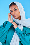 Muslim, woman and portrait with scarf in studio, blue background and color backdrop. Young female model, islamic culture and beauty of empowerment, proud religion and arabic fashion of elegant hijab