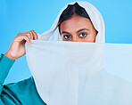 Muslim woman cover face with scarf in studio, blue background and color backdrop. Portrait, islamic female model and hijab for beauty, culture and confidence of religion, arabic fashion and style 