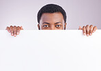 Mockup, space and portrait of a black man with a board isolated on a white background in a studio. Showing, branding and an African person peaking from a blank poster with mock up for advertisement