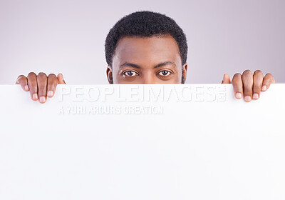 Buy stock photo Mockup, space and portrait of a black man with a board isolated on a white background in a studio. Showing, branding and an African person peaking from a blank poster with mock up for advertisement