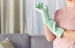 Woman, hands and gloves in housekeeping preparation for cleaning, dirt removal or disinfection in living room at home. Hand of cleaner ready to start spring clean service for safety with rubber glove