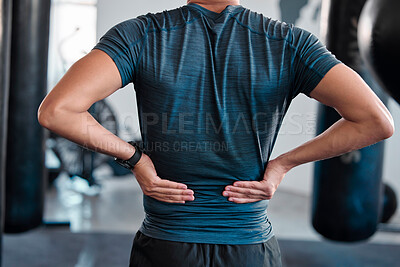 Buy stock photo Hands, back pain and injury with a sports man holding a muscle while training in a gym for health. Fitness, accident and anatomy with a male athlete suffering from an injured body during exercise