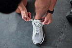 Top view, hands and tie shoes in gym to start workout, training or exercise for sports. Athlete, man and tying laces on sneakers to prepare for running, cardio or exercising for health or fitness.