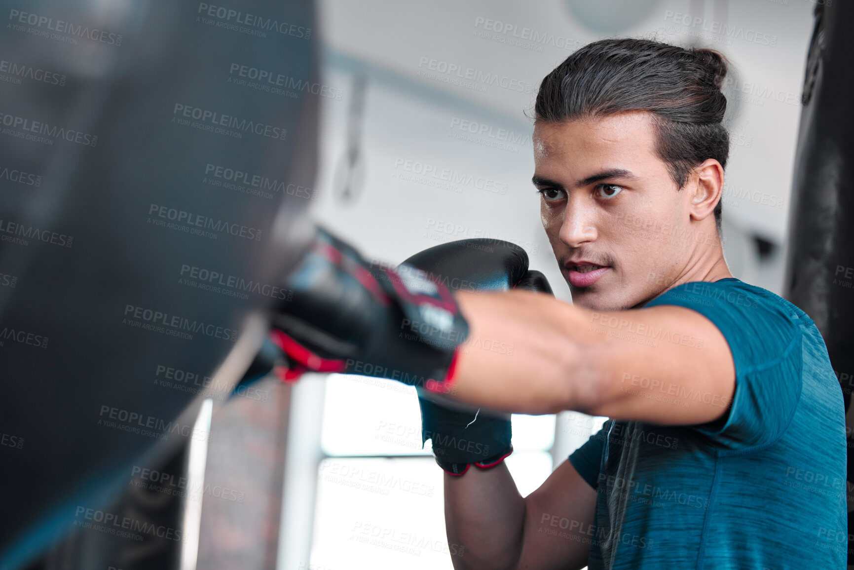 Buy stock photo Fitness, serious man and boxing for exercise, workout or practice training at the gym for fight. Active and focused male boxer hitting punching bag with gloves for intense sports or fighting skill
