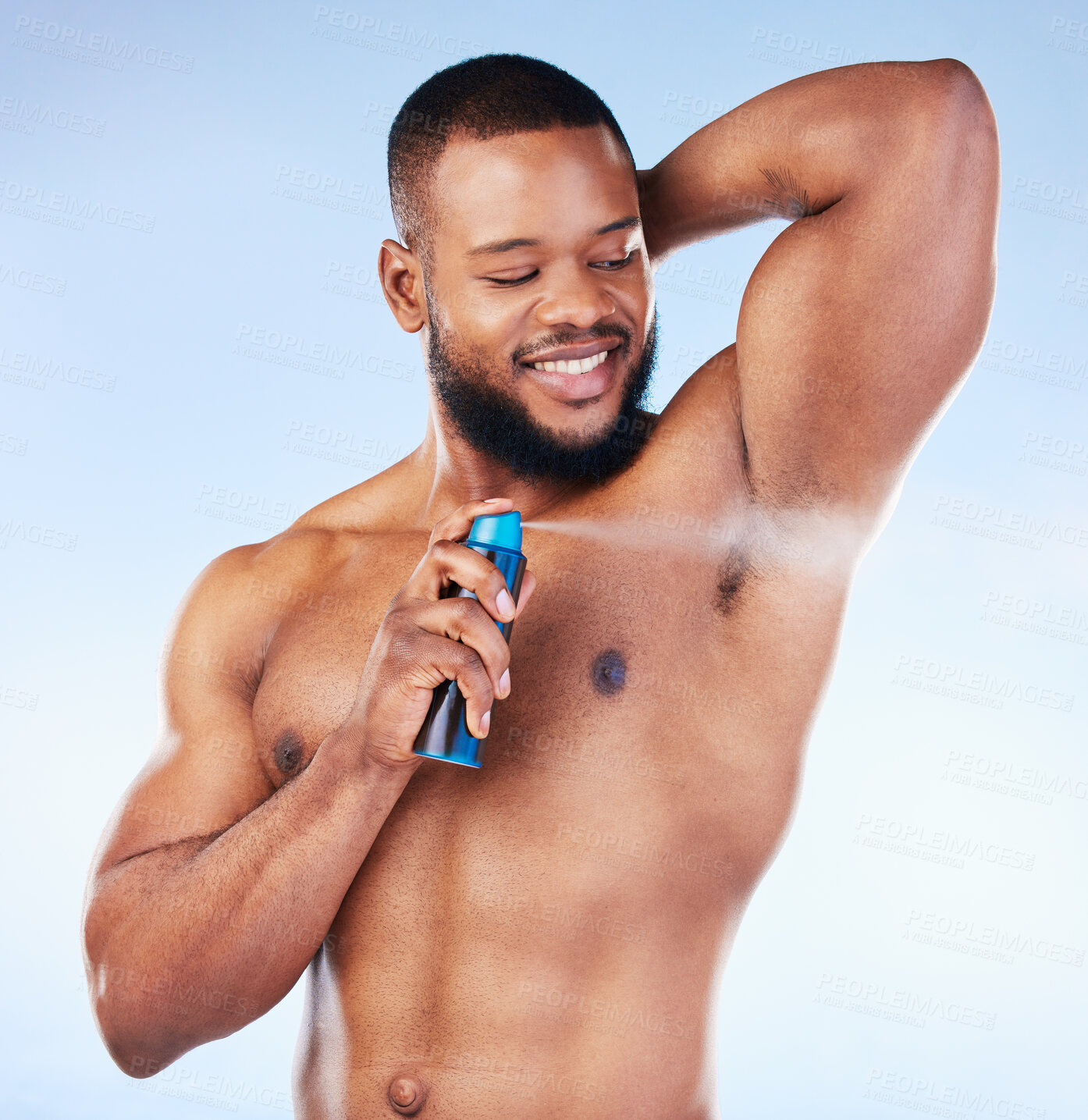 Buy stock photo Deodorant, spray and black man with smile in studio for beauty, grooming and body hygiene on blue background. Skincare, health and male spraying aerosol, fragrance and scent product for underarm