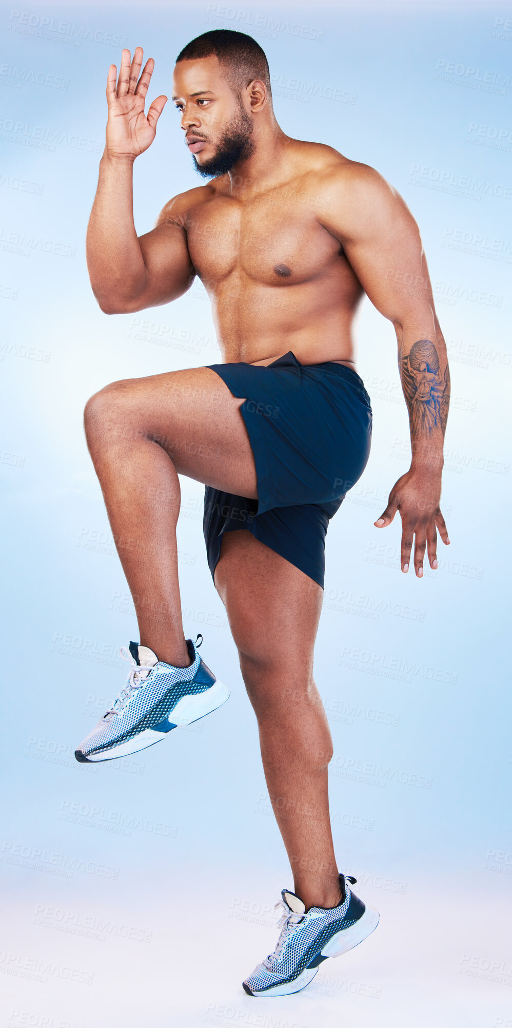 Buy stock photo Bodybuilder man, studio and training for running, explosive and balance with focus by blue background. Young fitness expert, body wellness and jumping for strong legs, muscle and health by backdrop