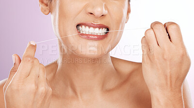 Face, woman and flossing teeth for cleaning, hygiene or tooth care in studio isolated on a purple background. Oral health, fresh breath or mature female model with dental floss or thread for wellness