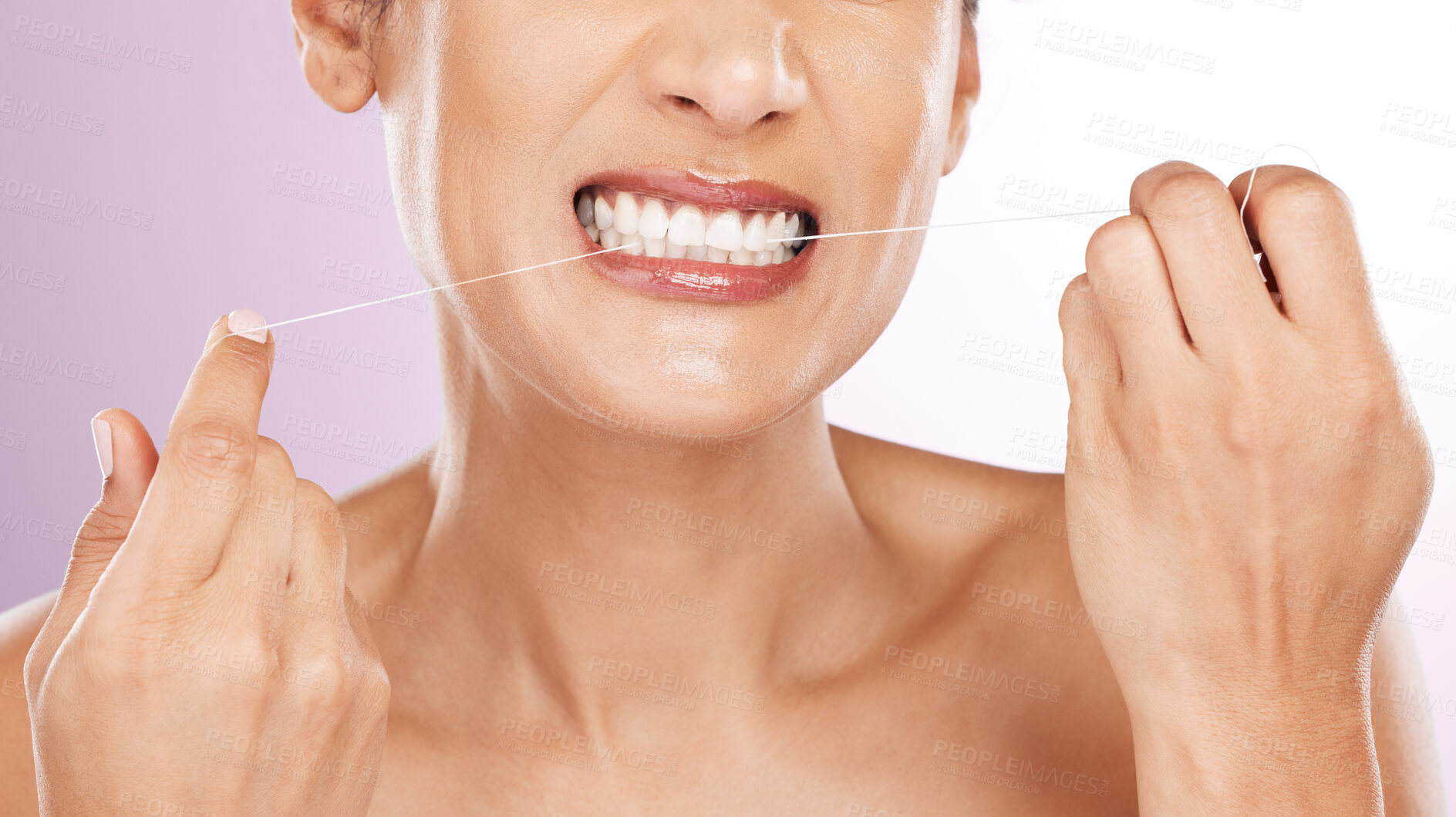 Buy stock photo Face, woman and flossing teeth for cleaning, hygiene or tooth care in studio isolated on a purple background. Oral health, fresh breath or mature female model with dental floss or thread for wellness