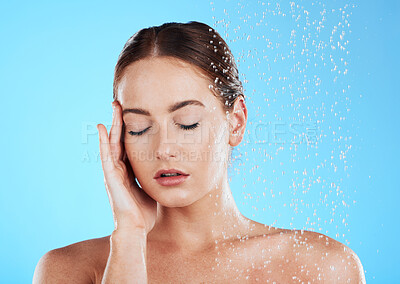 Buy stock photo Shower, water and relax woman in a studio feeling happy from cleaning and skincare. Wellness, splash and beauty routine of a female model excited from dermatology and self care with blue background