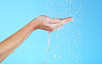 Hands, cleaning and water in a studio for skincare, safety and healthcare from virus. Isolated, blue background and hand wash for hygiene wellness and sanitary protection with liquid stream to clean