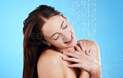 Buy stock photo Shower, water and happy woman in studio, blue background and cleaning for hygiene. Female model washing with wet drops for beauty, skincare and grooming for self care, happiness and wellness routine 