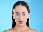 Shower, water and woman portrait in a studio feeling calm from cleaning and skincare. Wellness, face and beauty routine of female model in bathroom for dermatology and self care with blue background