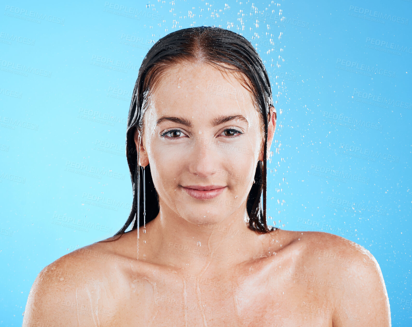 Buy stock photo Shower portrait, water and woman in a studio with a smile from cleaning and skincare. Wellness, bathroom and beauty routine of a female model relax from dermatology and self care with blue background