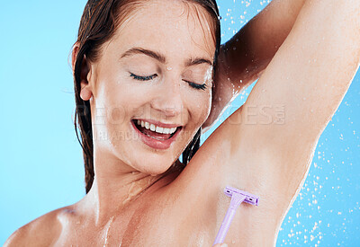 Buy stock photo Happy woman in shower, grooming and shaving armpit, hygiene and water drops with razor on blue background. Skincare, hair removal with female shaving underarms, eyes closed and smile in studio