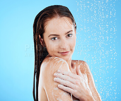 Buy stock photo Shower, water and woman portrait in a studio relax from cleaning and skincare. Wellness, soap wash and beauty routine of a female model excited from dermatology and care with blue background