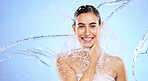 Water splash, portrait and woman shower in studio, blue background and healthy beauty of wellness skincare. Happy female model, wet and cleaning for hygiene, hydration and smile on color backdrop 