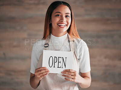 Buy stock photo Coffee shop, portrait and woman holding an open sign in studio on a blurred background for hospitality. Cafe, startup and small business with a female entrepreneur indoor to display advertising