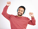 Headphones, happy and man dancing in a studio to music, playlist or album for entertainment. Happiness, dance and Indian male model moving to the radio or streaming a song by a white background.