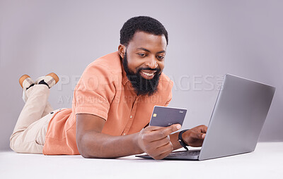 Buy stock photo Happy black man, credit card and laptop in studio for online shopping, digital financial payment and customer money. Male model, ecommerce and computer sales for finance, fintech and banking economy