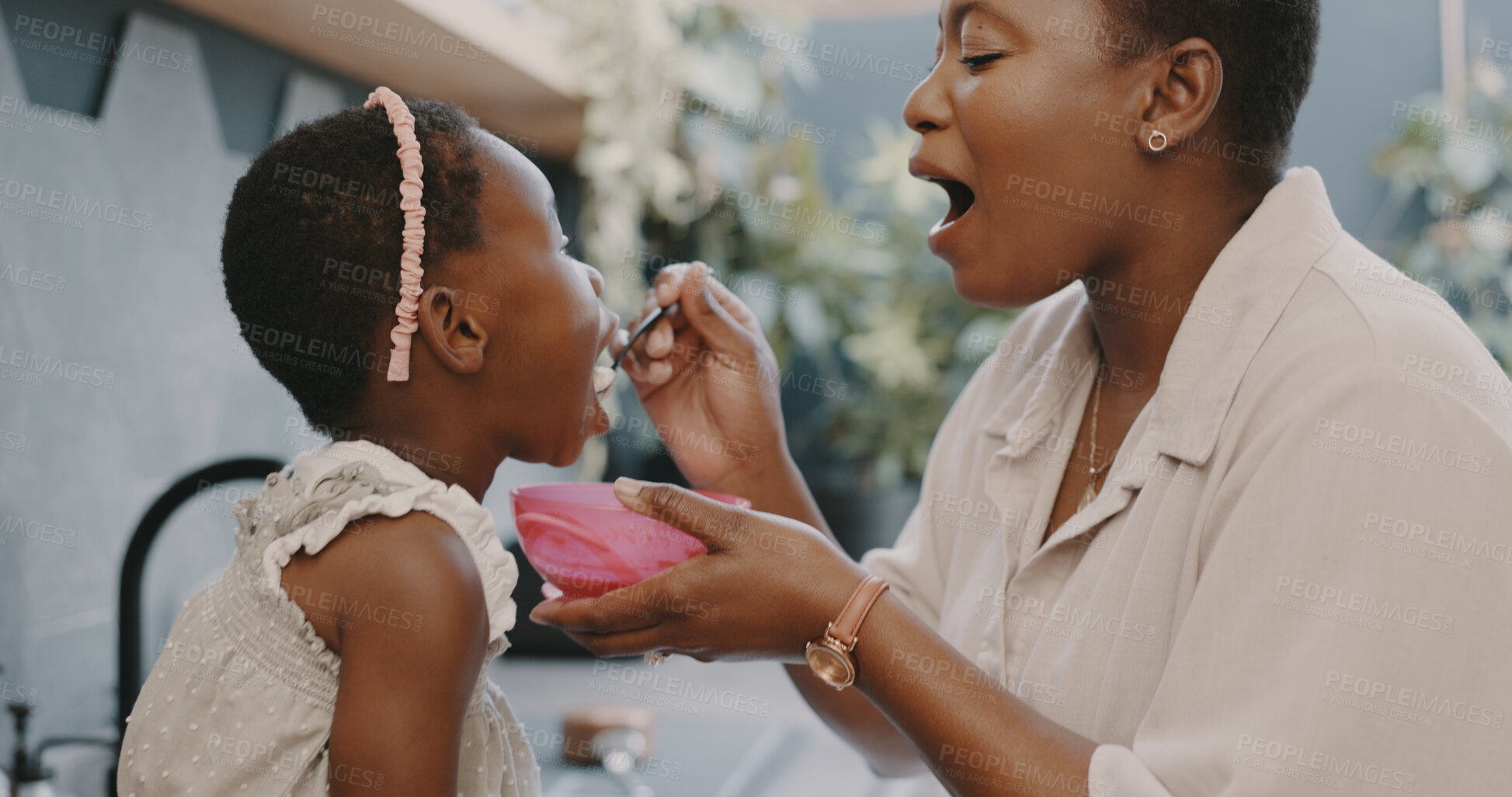 Buy stock photo Black family, food and a mother feeding her daughter in the kitchen of their home while together in the morning. Children, breakfast or care and a little girl child with her woman parent in a house