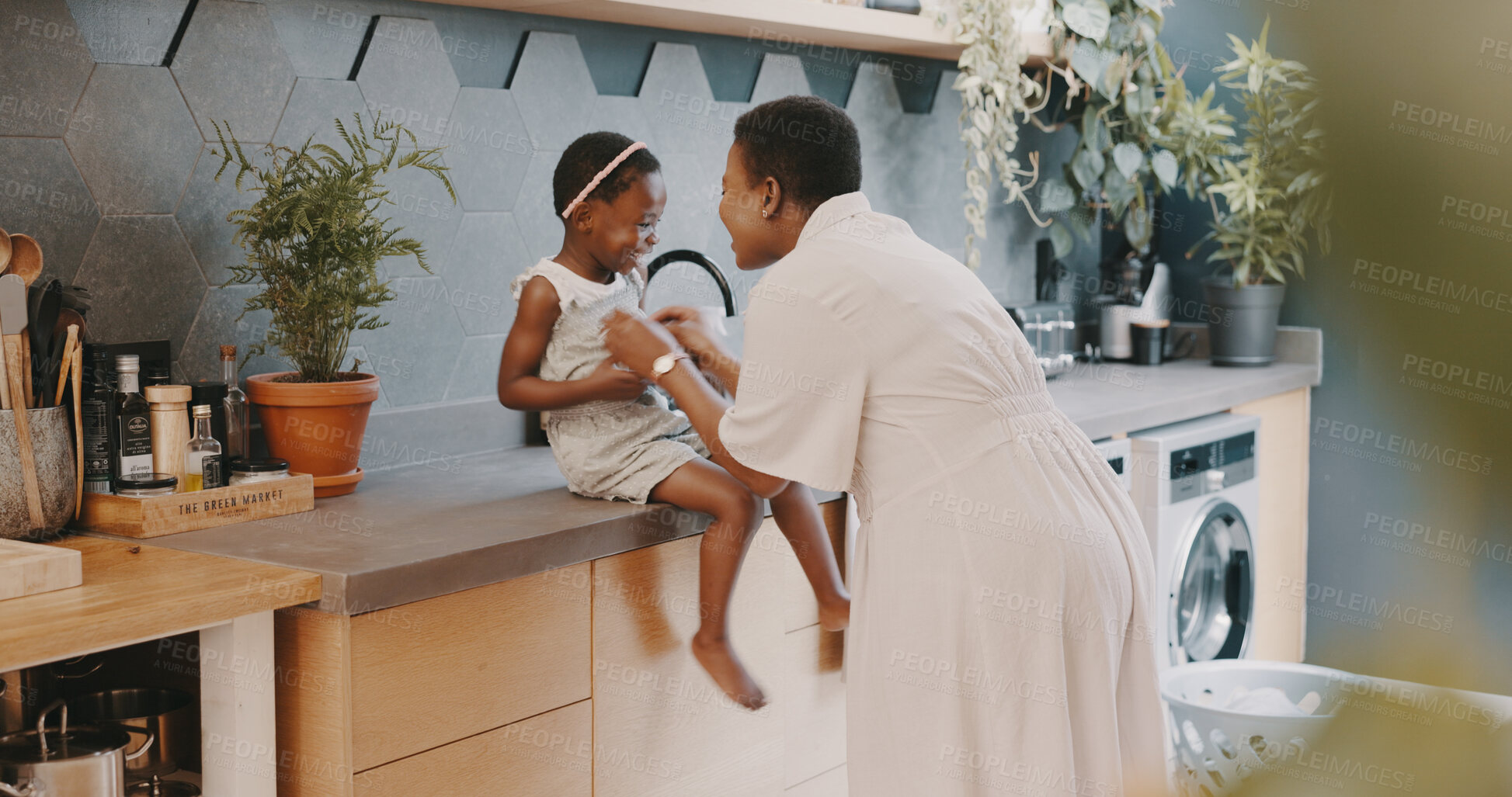 Buy stock photo Family, love or playing with a girl and mother laughing together in the kitchen of their home. Kids, funny and tickling with a black woman and happy daughter having fun while bonding in their house