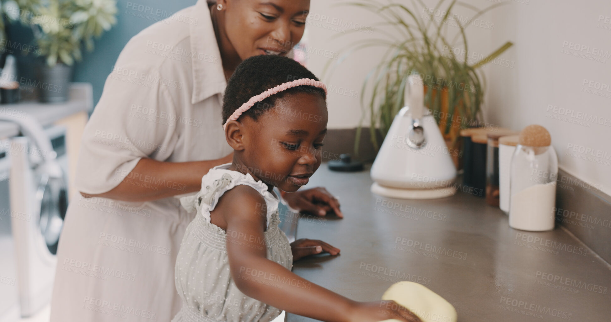 Buy stock photo Cleaning, mother and child at kitchen counter, helping and learning chores, hygiene or home care. Housework, teaching and black woman with happy daughter, cloth and spray bottle for dust on furniture