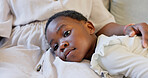 Family, mother and child at home talking, bonding and showing love while together on living room sofa. Black woman with girl kid lying on lap showing happiness, care and support in South Africa