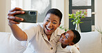 Smartphone, selfie and mother with child on living room sofa for social media post, parents blog update or family home celebration. Black family smile in cellphone portrait photography for online app