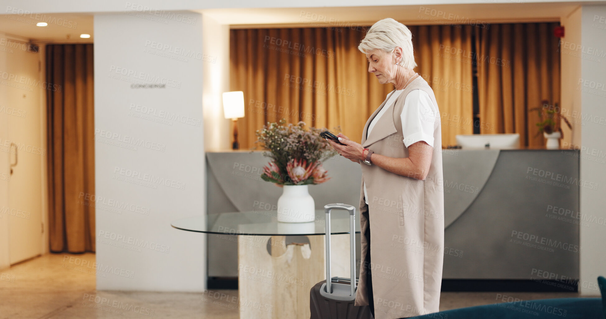 Buy stock photo Woman, hotel and reception lobby with smartphone, connection and business trip with email, suitcase and typing. Senior person, employee and travel agent with a cellphone, social media and hallway