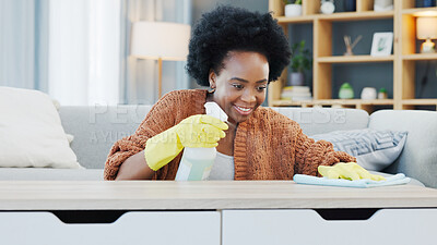 Young woman spring cleaning at home. Female sanitizing and wiping a table surface while doing routine chores to keep her apartment neat and germ free. Busy with housework for a hygienic living space