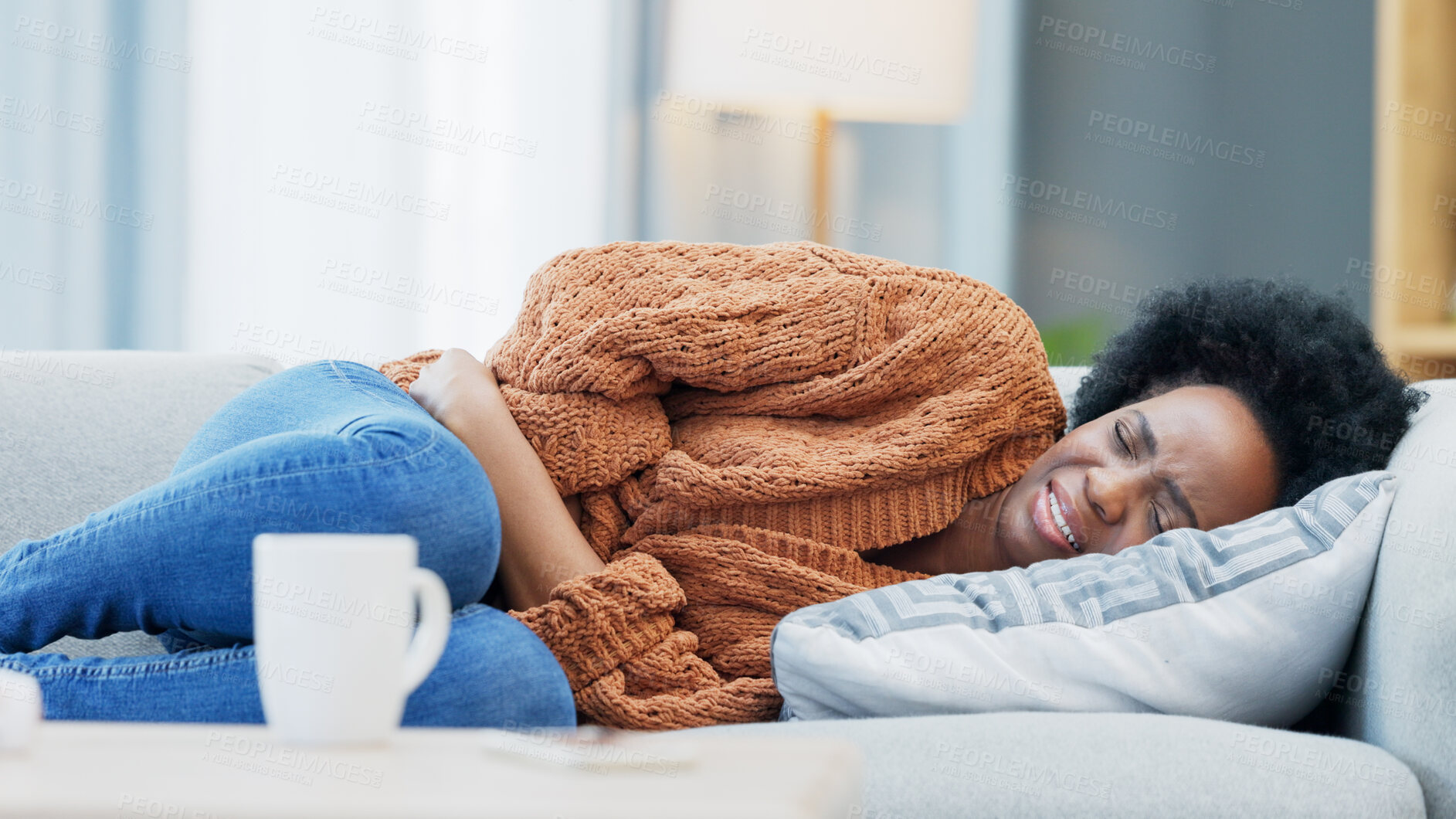 Buy stock photo Stomach pain, pms and black woman on a sofa with anxiety, gas or endometriosis at home. Menstruation, constipation  and African female with period crisis, stress or digestion problem in a living room