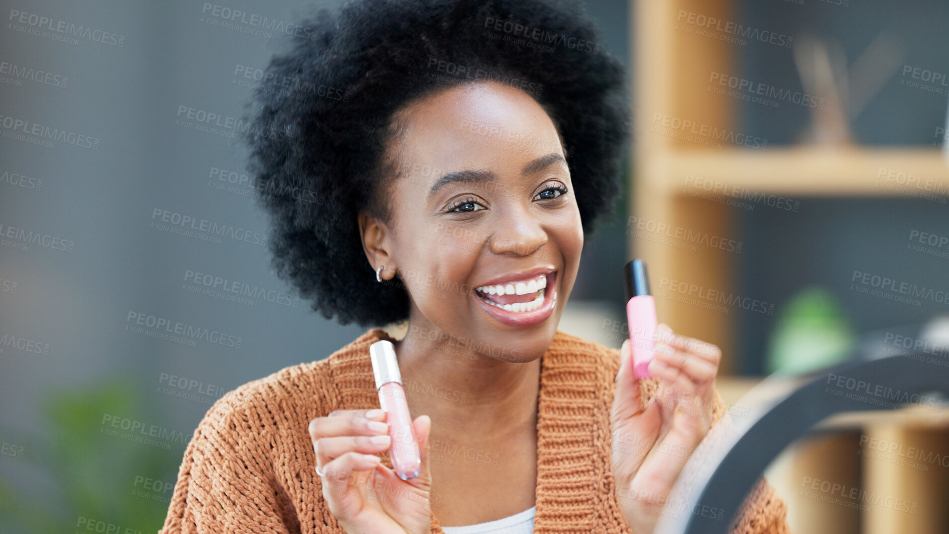 Buy stock photo Woman influencer recording a makeup tutorial for her beauty channel, blog or live streaming at home. Young African female content creator filming a video with cosmetic products in the living room.