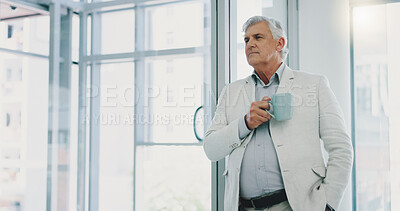 Successful businessman looking out window having, thinking and having a cup of morning coffee.