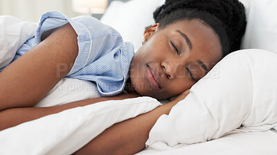 Sleep, bed and relax with a black woman sleeping in the bedroom of her home and dreaming. Resting, relaxing and peace with a young female lying on a pillow and under a duvet in a house in the morning