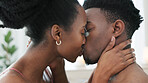 Couple kiss, bedroom sex and love on bed in house, erotic sexual energy in marriage and nude people being sexual together in home. Happy African man and woman kissing with passion in apartment