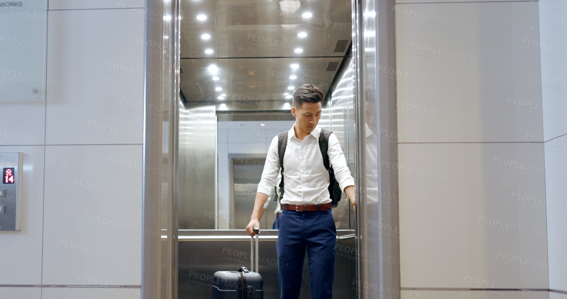 Buy stock photo Building, elevator and business man with travel luggage in a hotel for accommodation or check in. Airport, lift and Japanese male worker with suitcase for departure, trip or boarding flight process